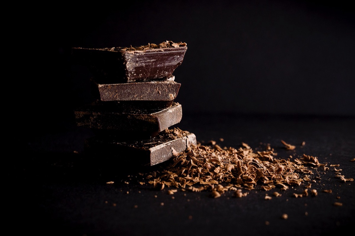 Carrés de chocolat noir empilés sur un fond sombre